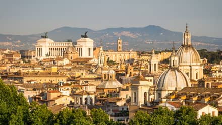 Rome skyline with Victor Emmanuel II Monument, Ponte Sant’Angelo, the Colosseum, and distant hills in the background.
